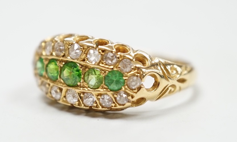 An Edwardian 18ct gold, demantoid garnet and diamond set oval cluster half hoop ring, size L, gross weight 3 grams.
